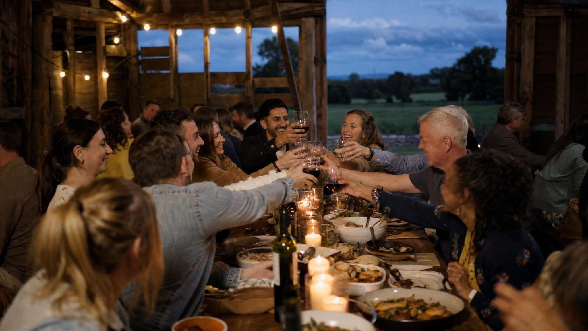 Ein Team-Offsite-Dinner an einer langen Tafel in einer Scheune auf dem Land