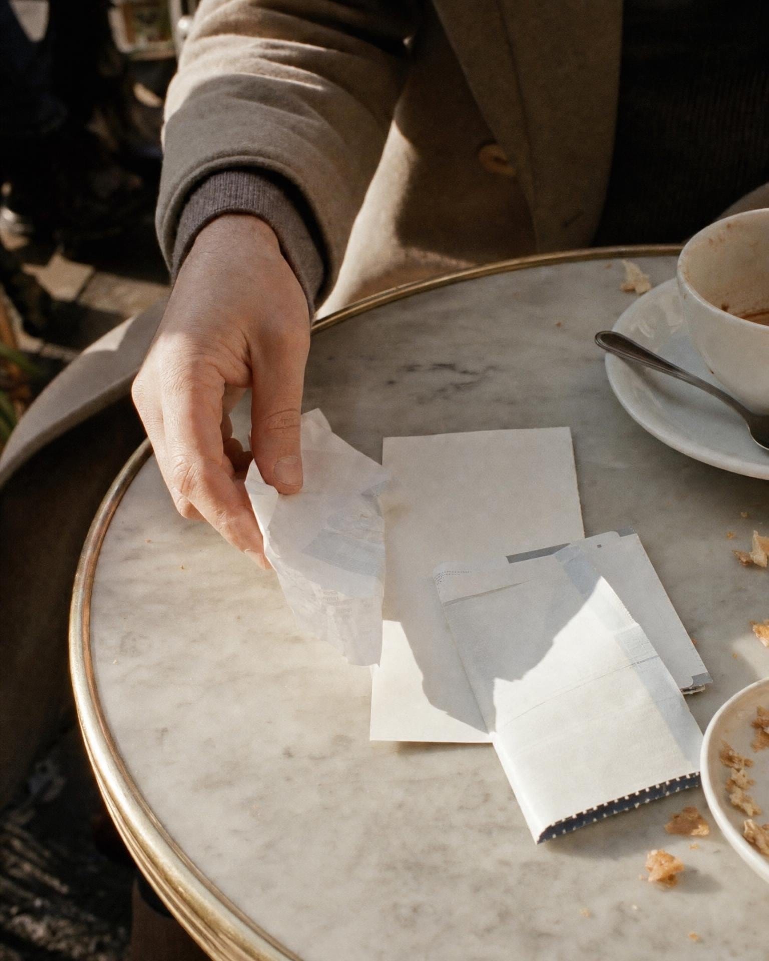 Ein Taxibeleg und eine Bordkarte liegen neben einem Kaffee auf einem Café-Tisch
