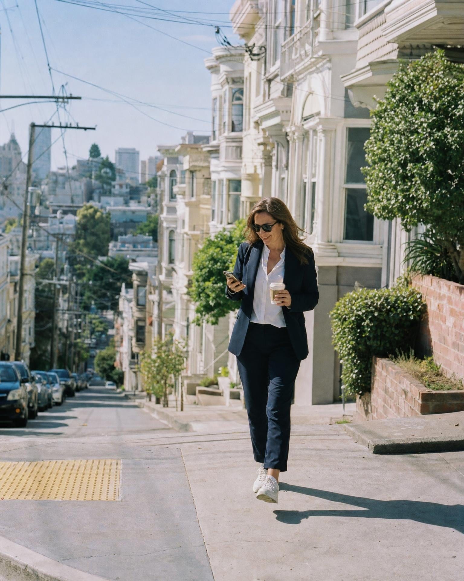 Ein Partner läuft mit einem Kaffee in der Hand zwischen Meetings einen Hügel in San Francisco hinunter